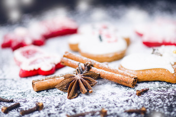 Christmas background decoration. Cinnamon, cookies shape such as heart and star. Flour and spices for a christmas baking on a dark background.