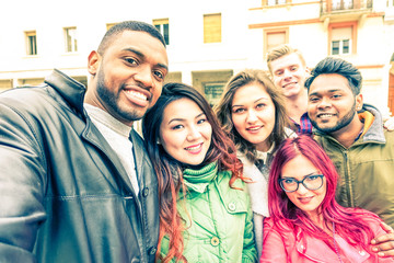Multiracial group of friends taking selfie standing on the street at winter season - Concept of friendship and fun together