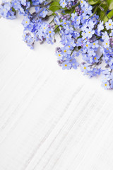 blue flowers frame on white wooden background