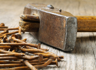 old used hammer on wooden board with rusty nails, macro, shallow depth of field