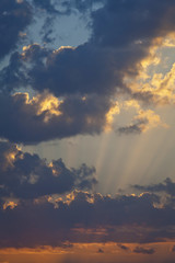 Cloudy sunrise sky with sun rays. Portrait orientation.