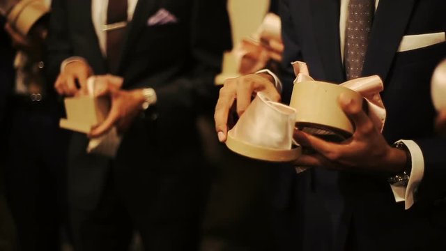 Men take pink silk ties from the box