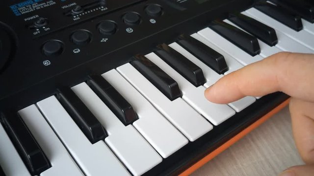 man hand playing synthesizer