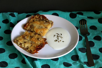Two pieces of meat pie and yoghurt on a plate. Selective focus. 