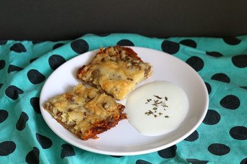 Two pieces of meat pie and yoghurt on a plate. Selective focus. 