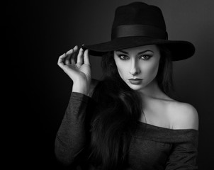 Elegant makeup woman in fashion hat posing on dark shadow backgr