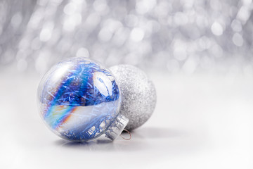 Fototapeta na wymiar Silver and Blue Christmas ornaments balls on glitter bokeh background with space for text. Xmas and Happy New Year theme