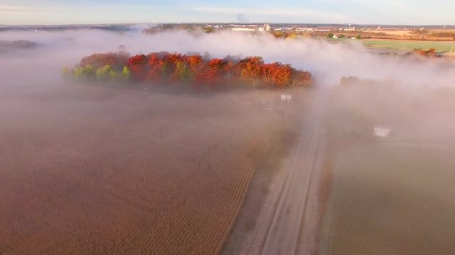 Sunrise over steaming, foggy autumn river, Fall colors adorning shore, aerial view.
