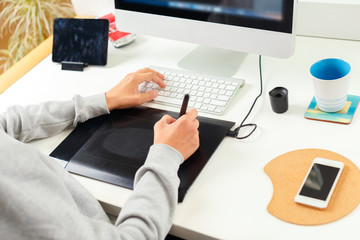 Fototapeta na wymiar Designer using graphic tablet at office
