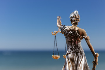 Back view of justice, femida or themis goddess sculpture on light copy space background