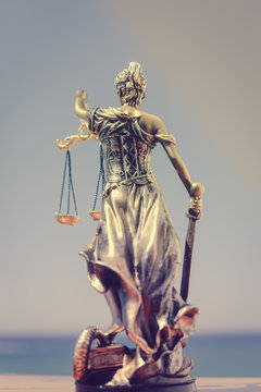Back view of justice, femida or themis goddess sculpture on light copy space background