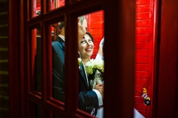Obraz na płótnie Canvas Wedding couple at the phone booth