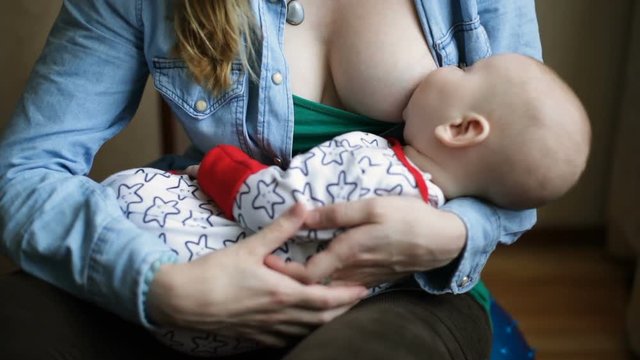 Mother feeding and lulling the baby