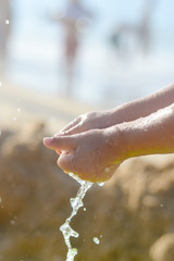 Fototapeta premium Happy child holding hands in water. Summer outdoors background