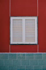 Closed window with shutters, red wall abstract design background