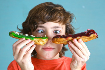 boy with eclair french dessert in hands