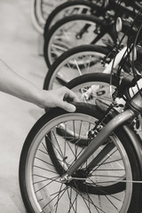 Black and white image close up on human hand checking bicycle tire