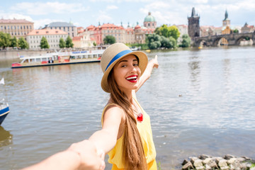 Obraz premium Young female traveler showing great view on Prague city. Follow me to Prague