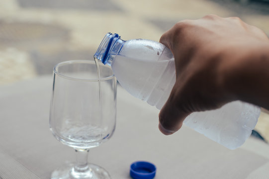 Closeup on pouring water from bottle into glass