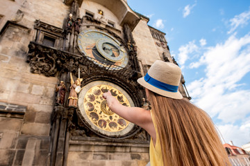 Obraz premium Female tourist pointing on the famous astronomical clock in Prague