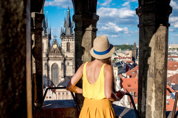 Naklejka premium Young female tourist enjoying great view on the old town of Prague from the top of the clock tower