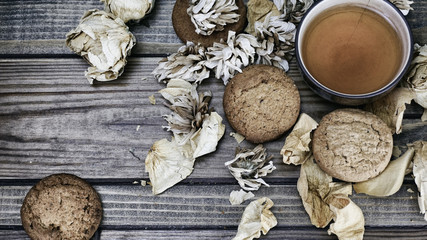 porcelain cup with tea and cookies lie on a wooden background