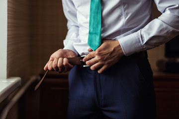 Fototapeta premium man putting on a belt, Businessman, Politician, man's style, mal
