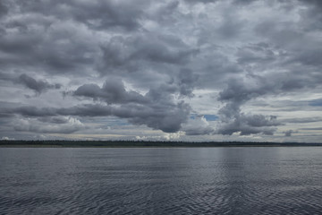 Fototapeta premium Dark silver clouds over the sea and the forest