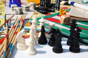 Set of table games with white and black chess pieces in the foreground