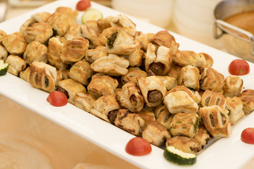appetizers mixed stuffed with vegetables and sausages served on a white tray