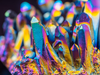Macro detail of Titanium rainbow aura quartz crystal cluster stone with shallow depth of field.