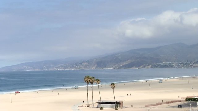 Santa Monica beach early morning clouds waves hills people from distance
