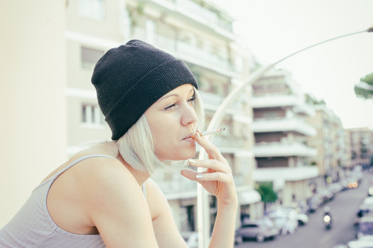 Young teen woman taking a break smoking cigarette