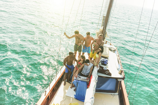 Group of young people drinking and dancig in sailing boat party