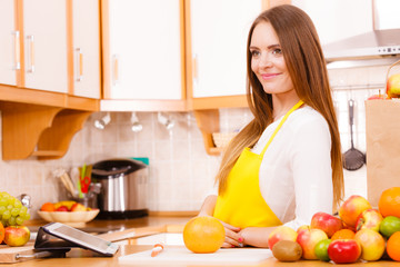 Obraz na płótnie Canvas Woman housewife in kitchen using tablet
