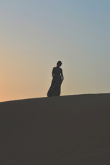 girl in the setting sun in the desert