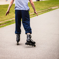 Male exercise outdoor on rollerblades wearing sportswear.