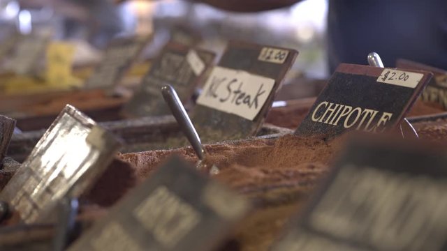 Assortment of spices being sold at market, with focus on Chipotle.
