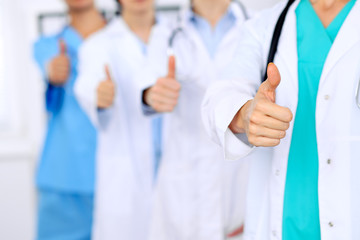 Group of doctors showing OK or approval sign with thumb up. High level and quality medical service, best treatment and patient care concept