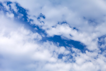 Colourful bright sky blue background with puffy clouds