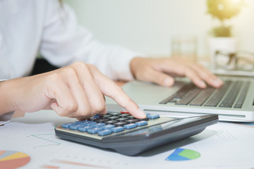 Business womon using a calculator to calculate the numbers