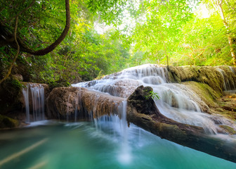 Jangle landscape with flowing turquoise water of Erawan cascade waterfall at deep tropical rain forest. National Park Kanchanaburi, Thailand