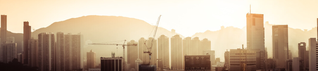 Hong Kong aerial cityscape panorama view with building construction near Victoria Harbor at sunset....