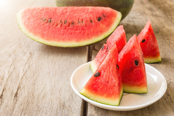 fresh slices of watermelon on a plate on a wooden background