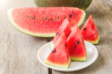 fresh slices of watermelon on a plate on a wooden background