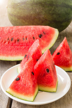 fresh slices of watermelon on a plate on a wooden background