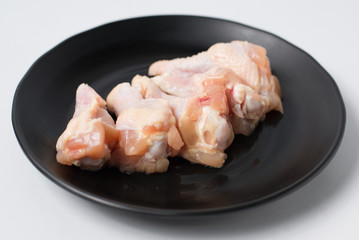 Fresh raw chicken legs on black dish