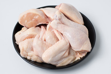 Fresh chicken legs on black dish