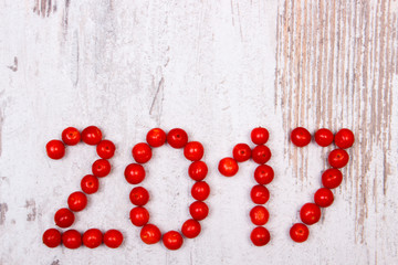 Happy new year 2017 made of red viburnum on old wooden background