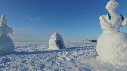 Ob Sea in winter with snow women and pissing dog. Novosibirsk, Siberia, Russia